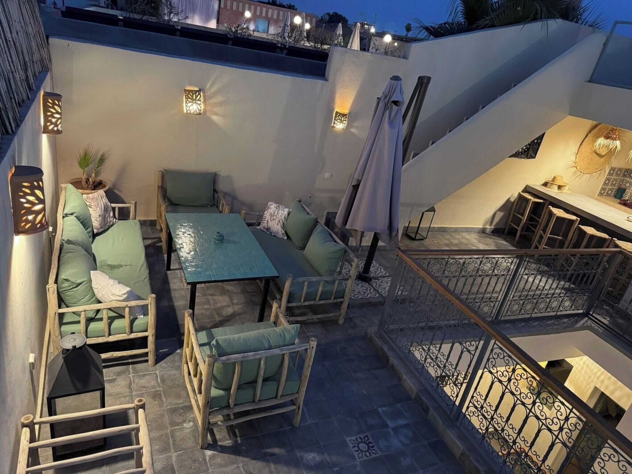 An outdoor patio area with a sofa set, a table, and a bar area with stools.