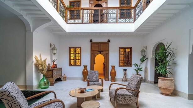 A spacious courtyard with a high ceiling, a wooden door, and a balcony with wrought iron railings. - Riad Marrakech Médina renovated, 5 air-conditioned rooms, with swimming pool (MARRAKECH)