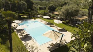 A large swimming pool with lounge chairs and umbrellas, surrounded by well-maintained lawns and trees. - Villa San Tommaso - Four Bedroom Villa, Sleeps 8 (Syracuse)