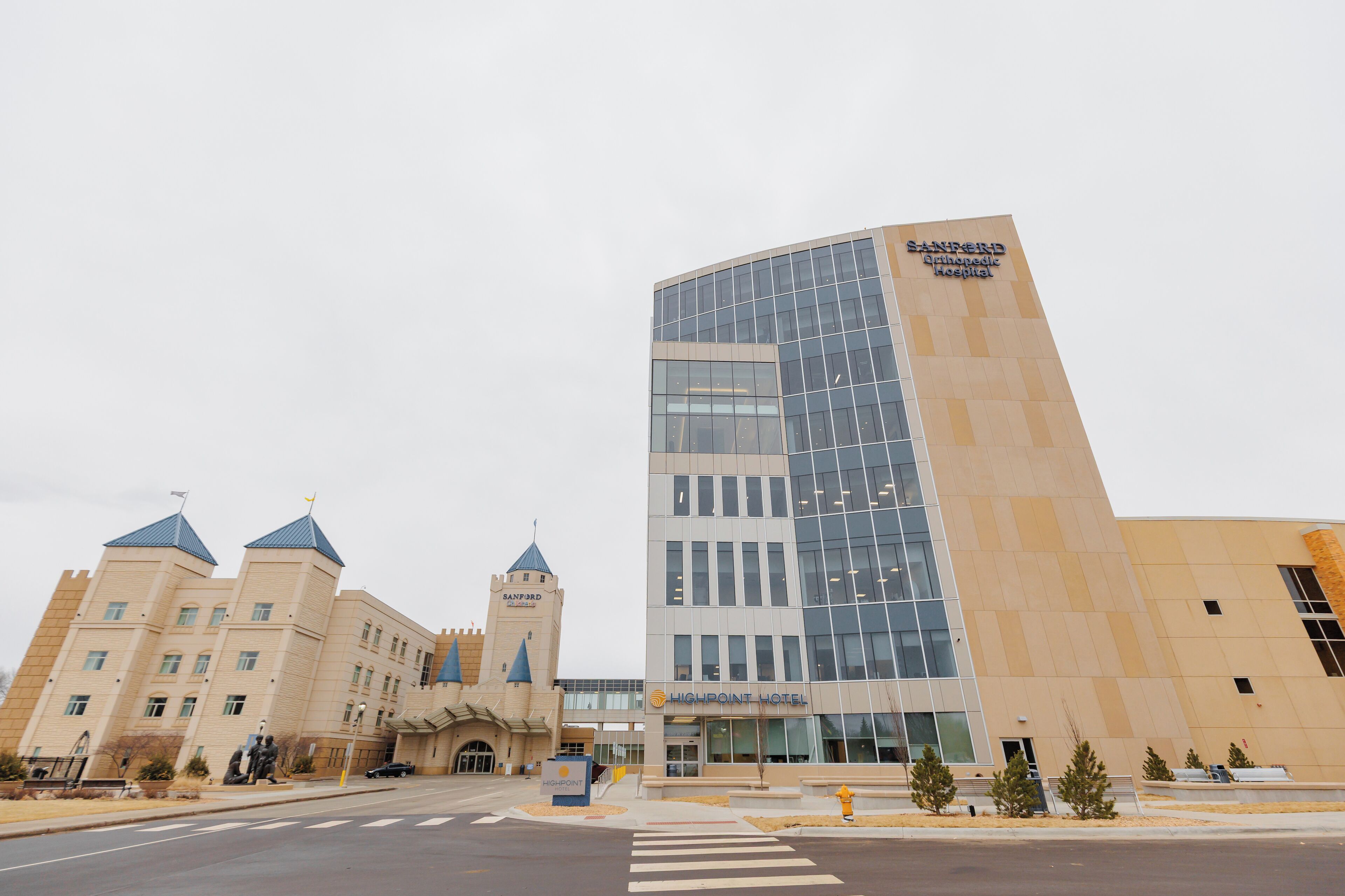 Un edificio moderno con fachada de vidrio y un letrero que indica 'Sanford Orthopedic Hospital'.