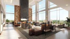 A spacious living room with a fireplace, large windows, and modern furniture. - Highpoint Hotel (Sioux Falls)