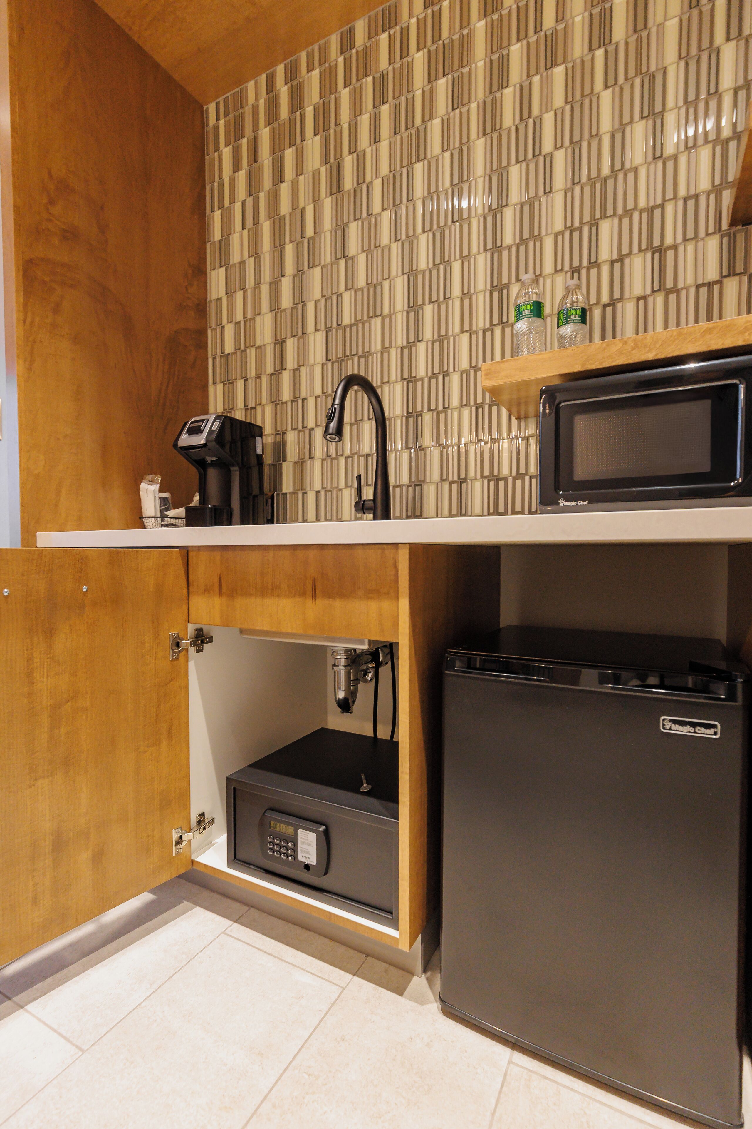 A compact kitchen with a microwave, coffee maker, and a small refrigerator.