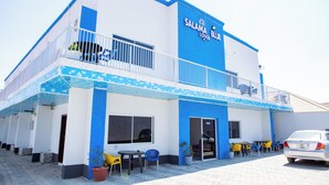 Un edificio de dos pisos con una decoración azul y blanca, que muestra un letrero que dice "SALAMA BLUE LODGE".