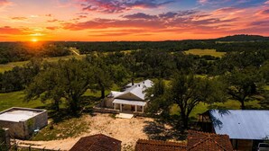 A rural property with a main house, a detached garage, and a fenced yard. - Peaceful 3-Bedroom Ranch Retreat Near Blanco (Blanco)