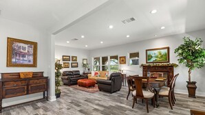 A spacious living room with a fireplace, a dining area with a wooden table and chairs, and a large potted plant. - Peaceful 3-Bedroom Ranch Retreat Near Blanco (Blanco)
