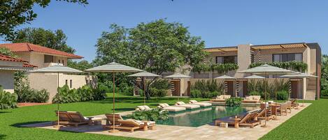 A modern outdoor pool area with lounge chairs and umbrellas, surrounded by well-maintained lawns and trees.