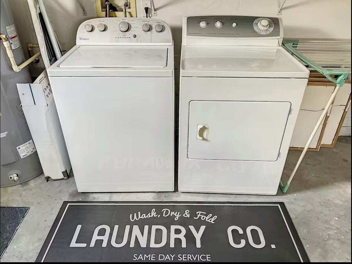 Two white Whirlpool washers with controls on top, placed next to each other.