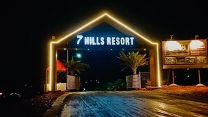 La entrada al Resort 7 Hills, con un letrero llamativo y un camino de acceso con puerta.