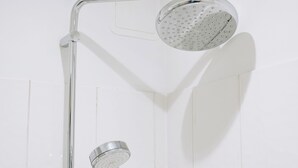 A shower with a handheld showerhead and a fixed overhead showerhead. - Traditional Central 2-Bed Apartment (Edinburgh)