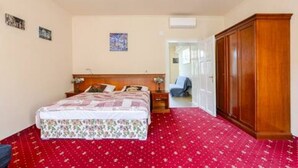 A bedroom with a bed, a wardrobe, and a door leading to another room. - Sunny Boutique Studio, 57 m², Art Nouveau hotel, ideal for extended stays (Wien)