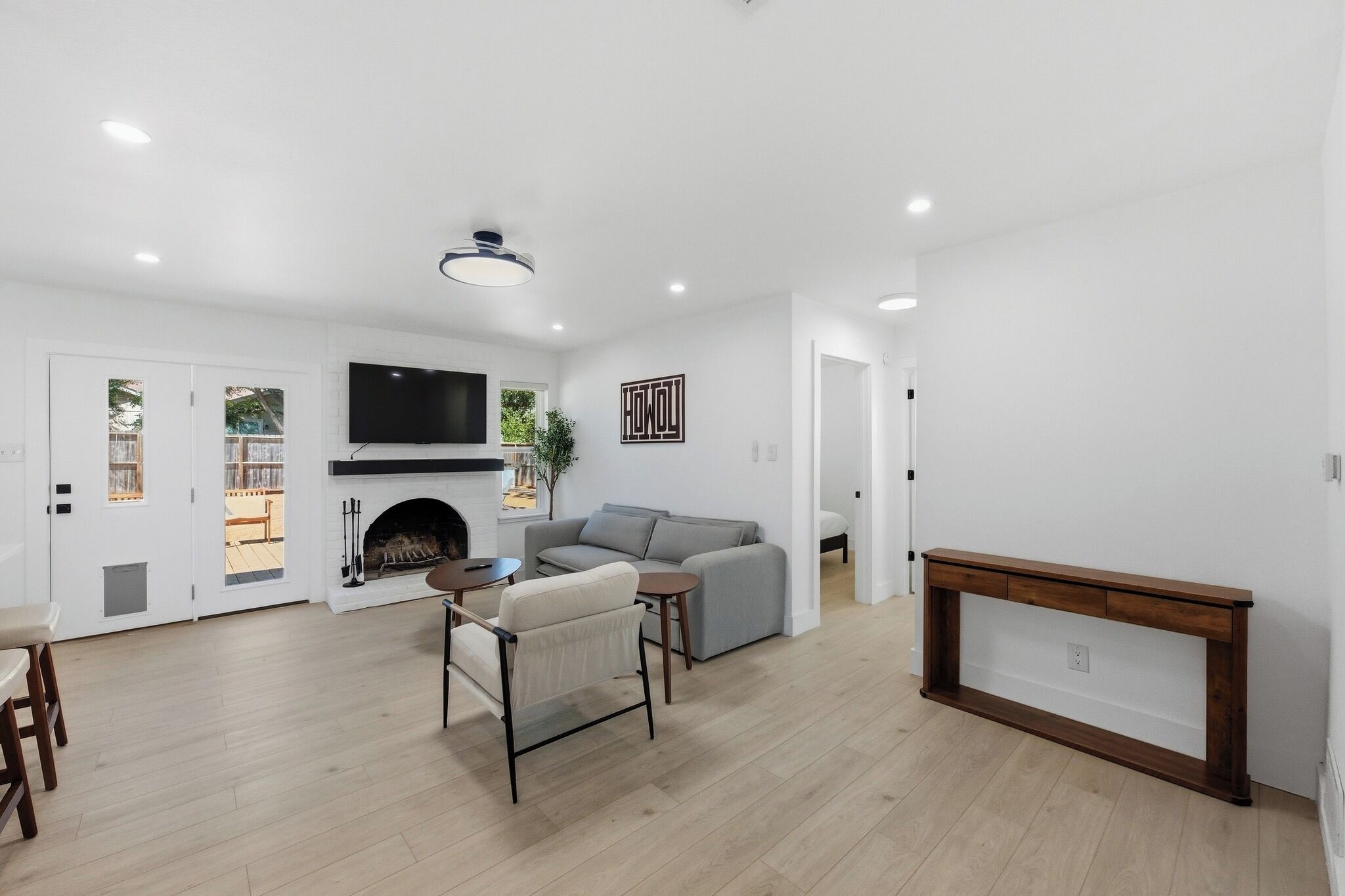 Un salon moderne avec une cheminée, un canapé, un téléviseur et une console.