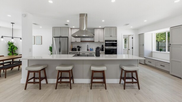 A modern kitchen with a central island, bar stools, and a large window. - Austin Escape: Stylish 3BR/4 Beds + Private Pool (Austin)