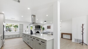 A modern kitchen with a large island, white cabinetry, and a built-in stove. - Austin Escape: Stylish 3BR/4 Beds + Private Pool (Austin)