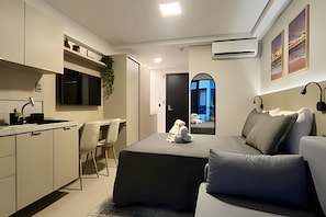 A modern living space with a kitchen, dining area, and seating area. - Beach Haus  (João Pessoa)