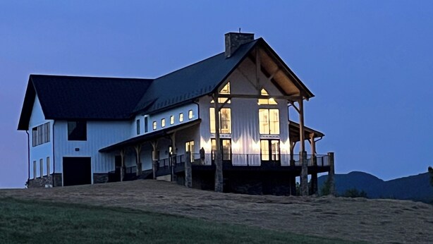 A large, two-story house with a steeply pitched roof, multiple windows, and a porch with railings. - Meridian House - A Blue Ridge Mountain Escape for Memories (Buena Vista)