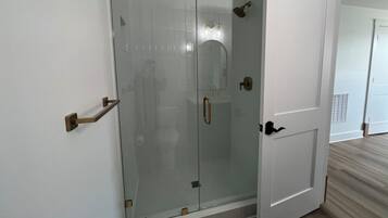 Een douche, handdoeken, zeep, toiletpapier