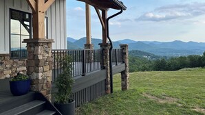 A wooden deck with stone pillars, a stone wall, and a view of mountains. - Meridian House - A Blue Ridge Mountain Escape for Memories (Buena Vista)