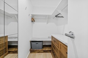 Ein modernes Badezimmer mit einem Holzbadschrank, einem weißen Waschbecken und einer Duschkabine.