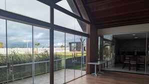 Una habitación amplia con ventanas grandes, un comedor y vistas al exterior.