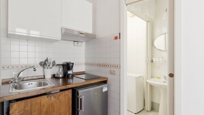 Eine Küche mit Spüle, Herd und Kühlschrank, sowie ein Badezimmer mit Spüle und Spiegel.