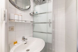 Regadera, secadora de cabello, toallas, papel de baño 