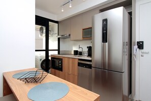 Una cocina moderna con refrigerador de acero inoxidable, lavavajillas y microondas.
