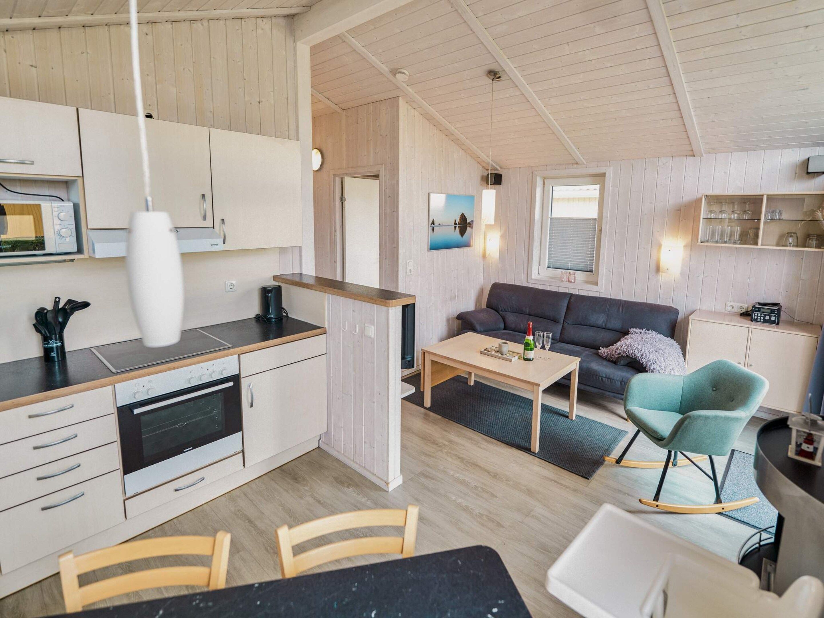 Une cuisine moderne avec un coin repas, un canapé et un fauteuil à bascule.