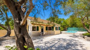 A house with a swimming pool, a patio, and a tree in the foreground. - Villa Old Vineyard - One Bedroom Villa, Sleeps 2 (Paxi)