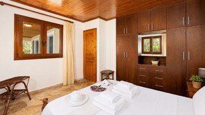 A bedroom with a bed, wooden wardrobe, a window, and a door. - Villa Old Vineyard - One Bedroom Villa, Sleeps 2 (Paxi)