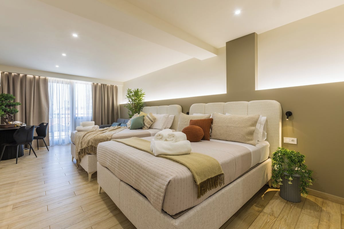 Une chambre d’hôtel moderne, dotée d’un grand lit, d’un bureau et d’une plante en pot.
