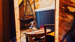 A modern interior with a hanging chair, a round table, and a staircase. - Ô Saphir Spa - House N2 (Denain)