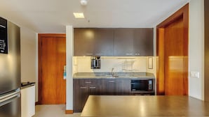 Une cuisine moderne avec des meubles en bois foncé, des appareils électroménagers en acier inoxydable et un plan de travail en granit.
