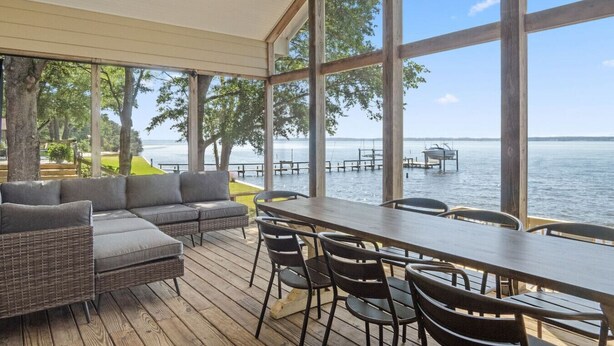 A covered outdoor seating area with a view of the water. - Ferry Breeze Beach House – NC Coastal Escape (Minnesott Beach)