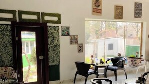 Ein modernes Wohnzimmer mit Marmorboden, schwarzem Möbel und Blick ins Freie.
