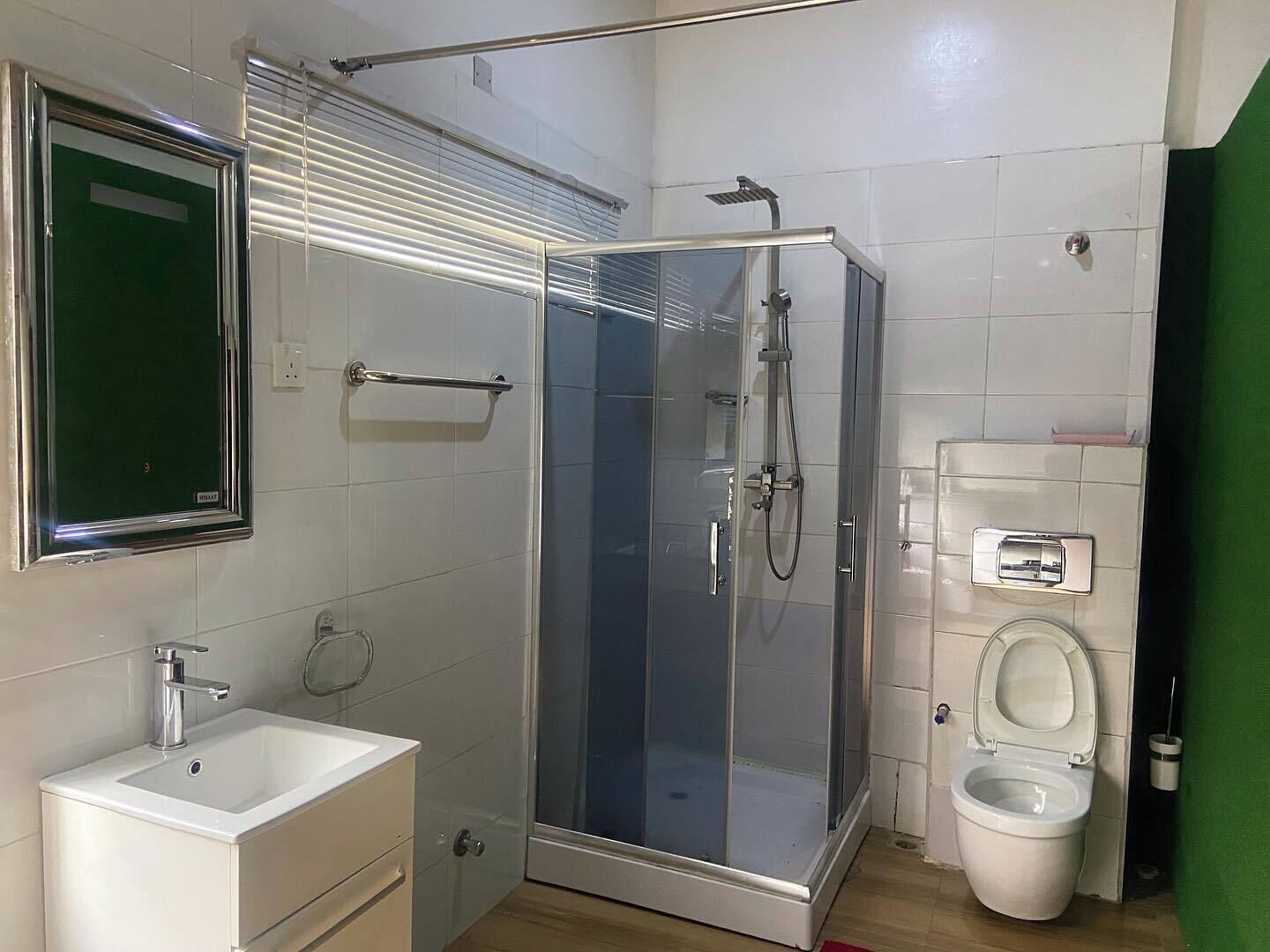 Une salle de bain avec une douche à parois de verre, des toilettes et un lavabo avec un miroir au-dessus.