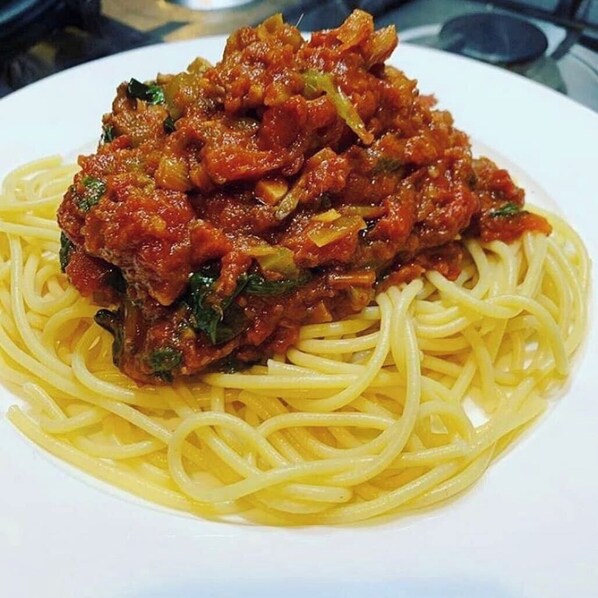 A plate of spaghetti with a meat-based sauce. - 6129 Luxzri Apartment (Abuja)