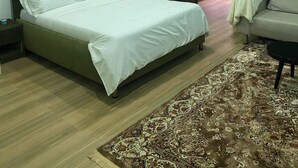 Ein modernes Schlafzimmer mit Bett, einer grünen Wand, einer Küchenzeile und einer Couch.