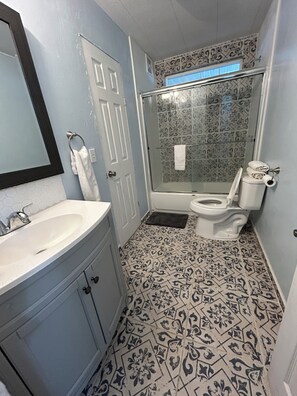 A bathroom with a sink, toilet, and shower.