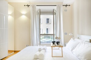 Une chambre d’hôtel avec un lit, une table avec des articles de toilette et une fenêtre avec des rideaux.