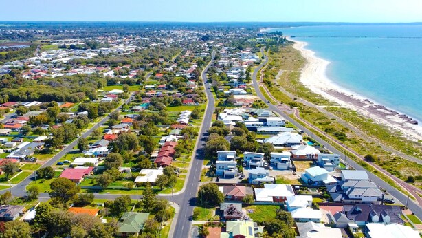 An aerial view of a coastal residential area with houses, roads, and a beach. - Marine Holiday Home - Geographe (Geographe)