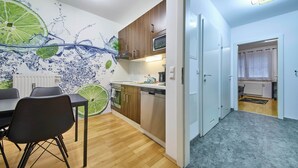 Une cuisine moderne avec des meubles en bois, un four à micro-ondes et un lave-vaisselle. Il y a également un coin repas avec une table et des chaises.