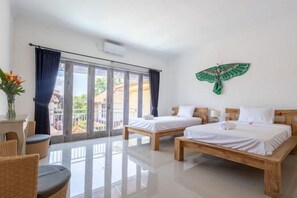 A hotel room with two beds, a balcony, and a view of the outside. - Villa Chunga-changa (Bali)