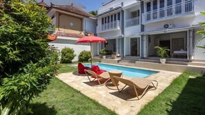 Une maison à deux étages dotée d’une piscine, d’un espace extérieur aménagé et d’un jardin bien entretenu.