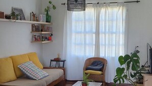 Un salon comprenant un canapé, un fauteuil, une table basse et une bibliothèque.