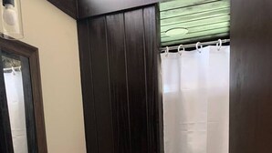 Une salle de bain équipée de toilettes, d’un lavabo et d’un rideau de douche.