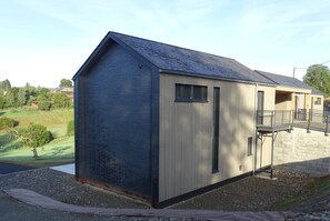 Een klein, laag gebouw met een schuin dak en een houten deur.