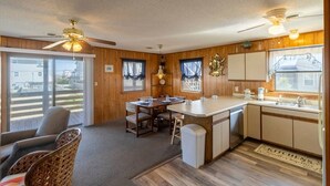 Una habitación acogedora tipo cabaña con comedor, cocina y un ventanal grande.