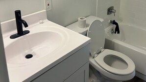 Un bagno con lavandino, WC e vasca da bagno bianchi.