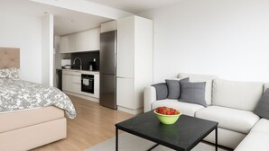 Un apartamento moderno con un dormitorio, sala de estar y cocina.