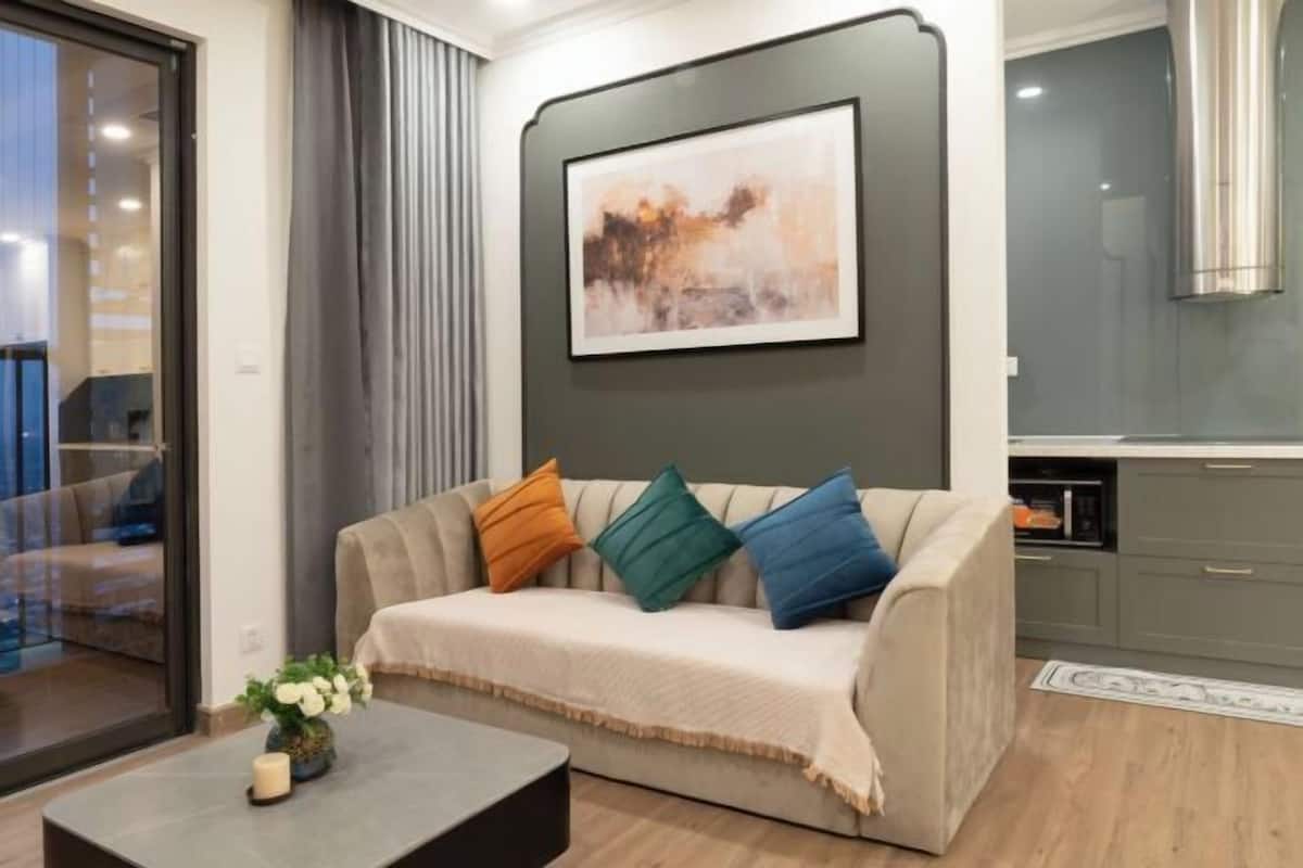 Un salon moderne avec un canapé, une table basse et un tableau accroché au mur.